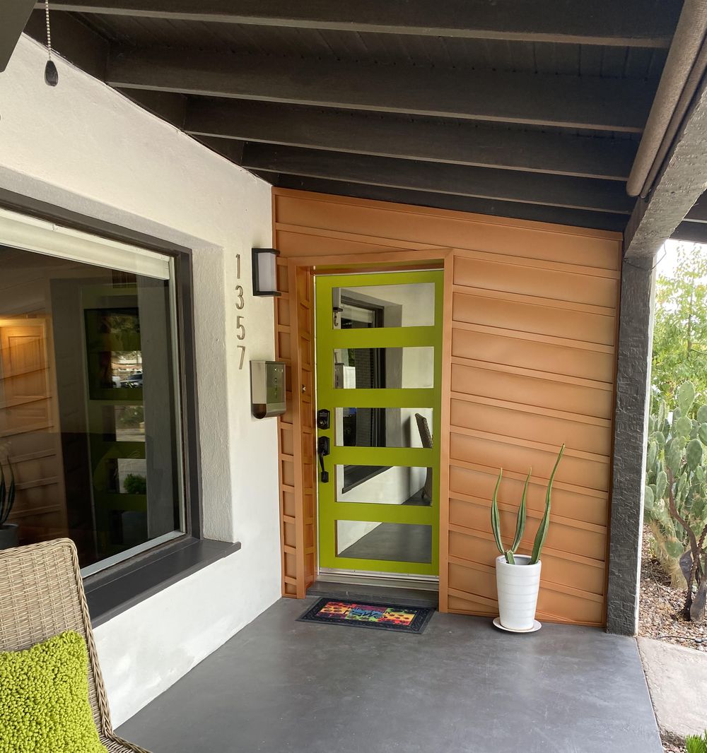 Front entryway clad in custom built Copper Penny batten board metal panel around a green door