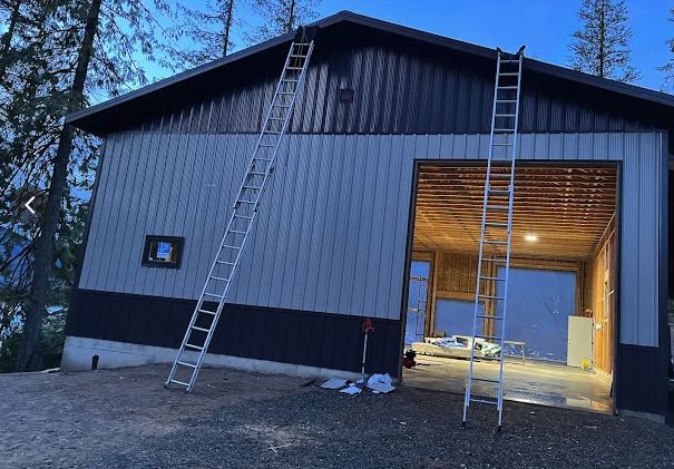 Metal roof and two-tone siding installed on a new shop building