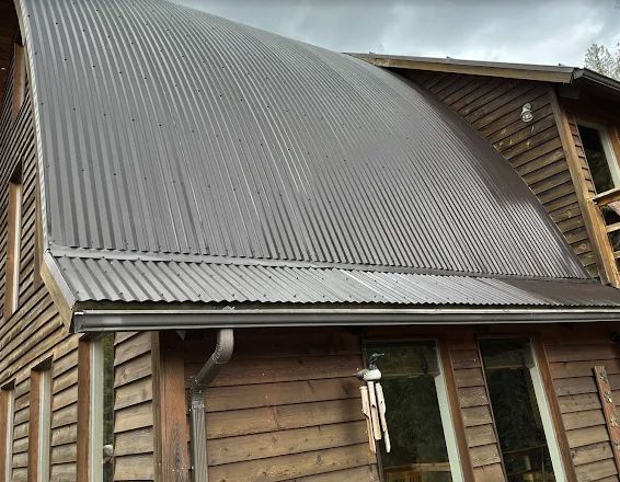 Corrugated metal roof and gutter on a cedar-sided home