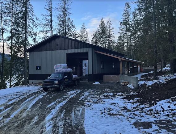 New metal roof and dark metal siding on a shop building in the snow
